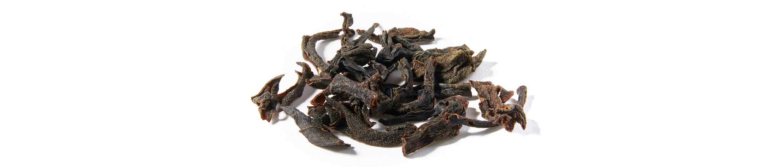 Luxurious Pekoe loose tea leaves arranged on a white background
